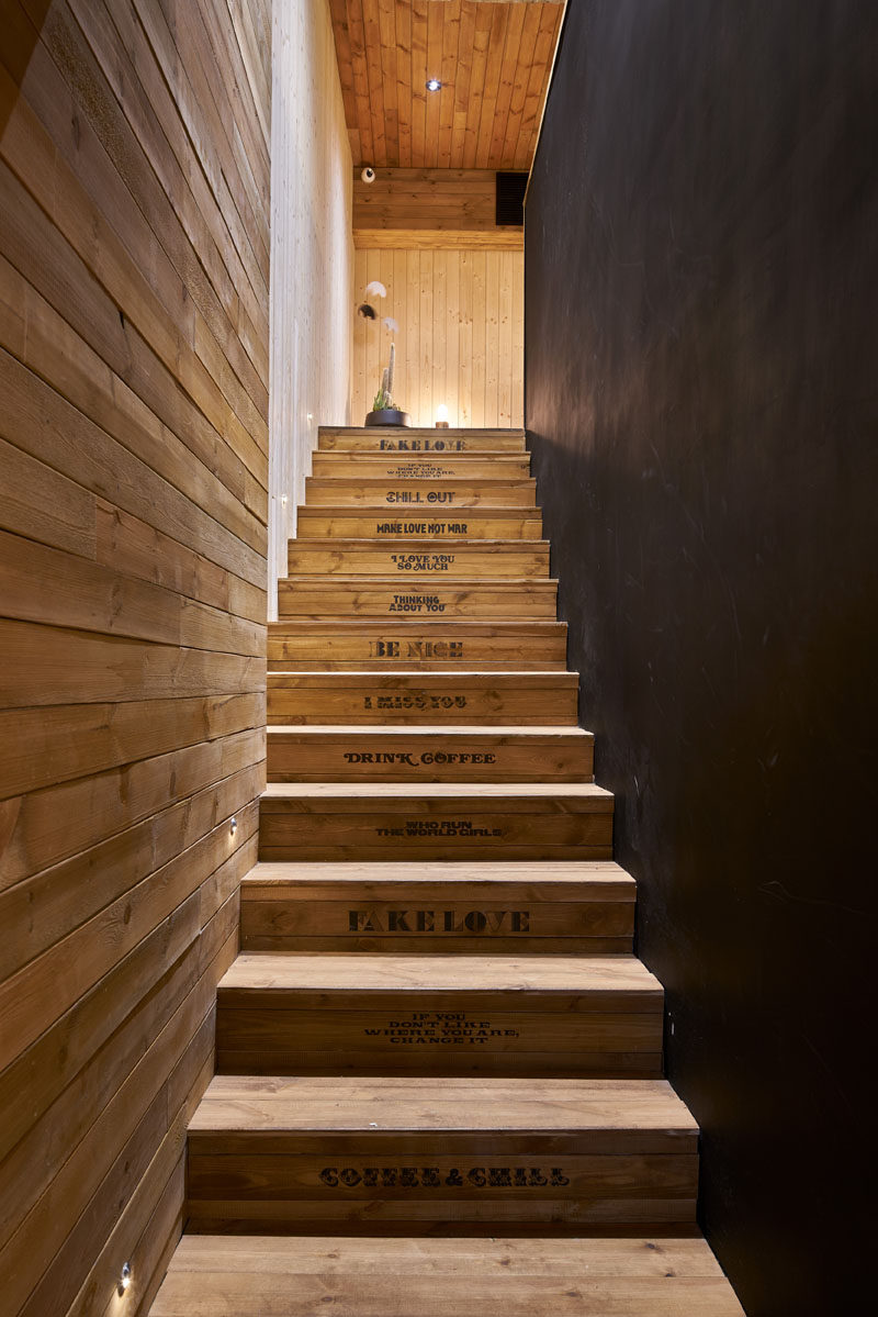 In between black and wood walls in this modern coffee shop, is a set of wood stairs stamped with sayings like "Be Nice" and "Chill Out", lead to the upper level of this coffee shop. 