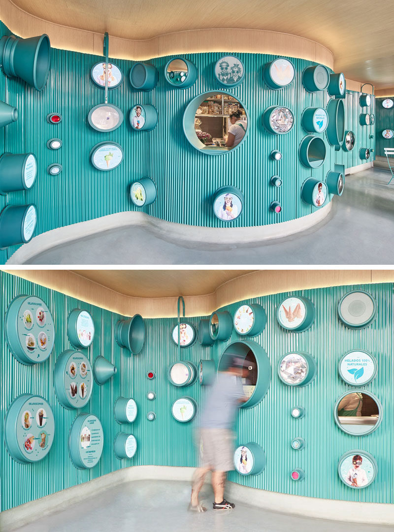 Inside this modern ice cream shop, the menu is located within the different lenses on the wall, and from this angle, you can see how the interior curves in the space.