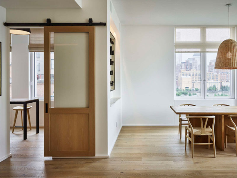 This sliding barn door divides the kitchen and dining area from the living room, and compliments the rest of the interior thanks to the warm tone of the wood.