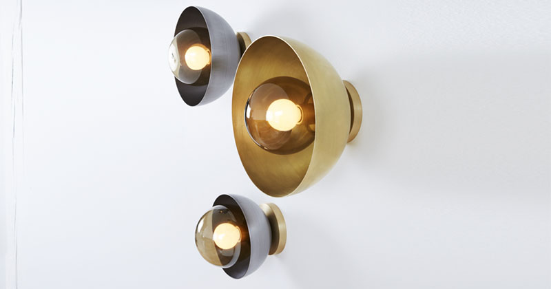 These modern metallic wall sconces are made from hand blown glass, with a steel or brass cover. 