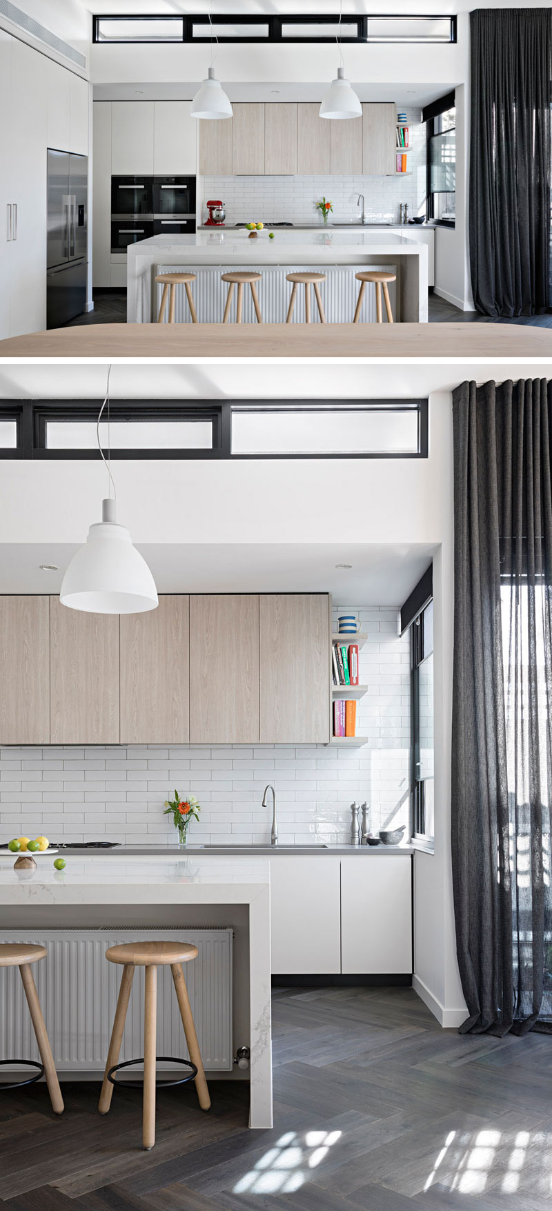 The modern kitchen has a large white island that sits below two pendant lamps. White rectangular tiles have been used as a backsplash, below light wood cabinets.