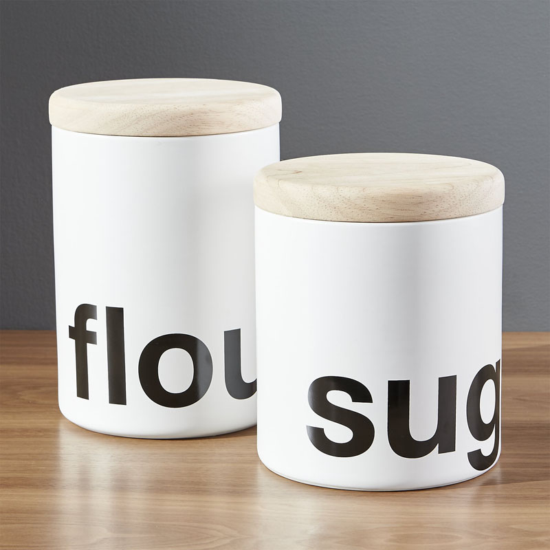It won't be hard to figure out what's inside these modern white stoneware canisters thanks to the bold black text. A hardwood lid keeps everything secured inside. #PantryIdeas #StorageIdeas #KitchenStorage #KitchenJars #ModernJar #ModernCanister #PantryJars