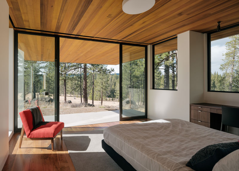 This modern bedroom located on the lower floor of the house, has large sliding glass doors that open up to a small private patio.