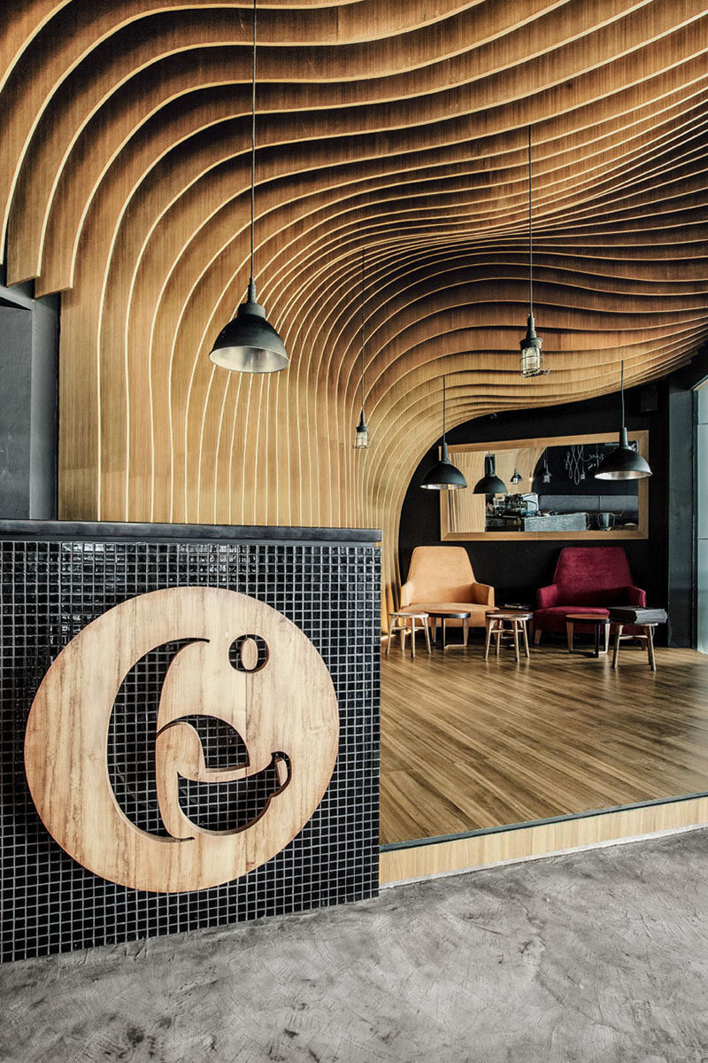 The wood sign at the front of this cafe communicates the name of the cafe, while the coffee mug lets people know that coffee is likely the main offering.