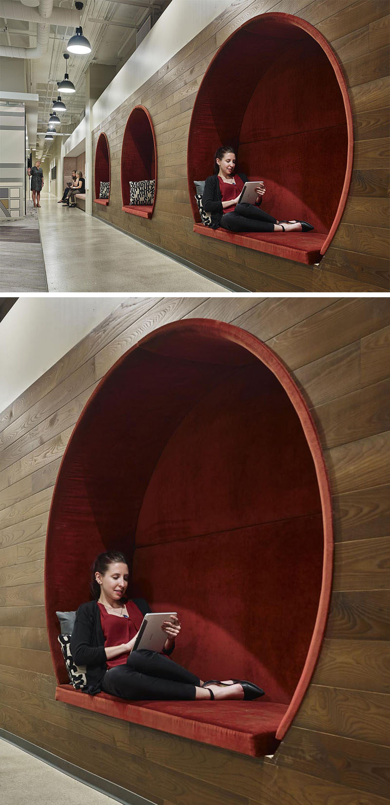In this modern office, three circular seating nooks with red upholstered cushions are embedded within a dark wood wall, creating a cozy and intimate environment to work or take time away from a screen.