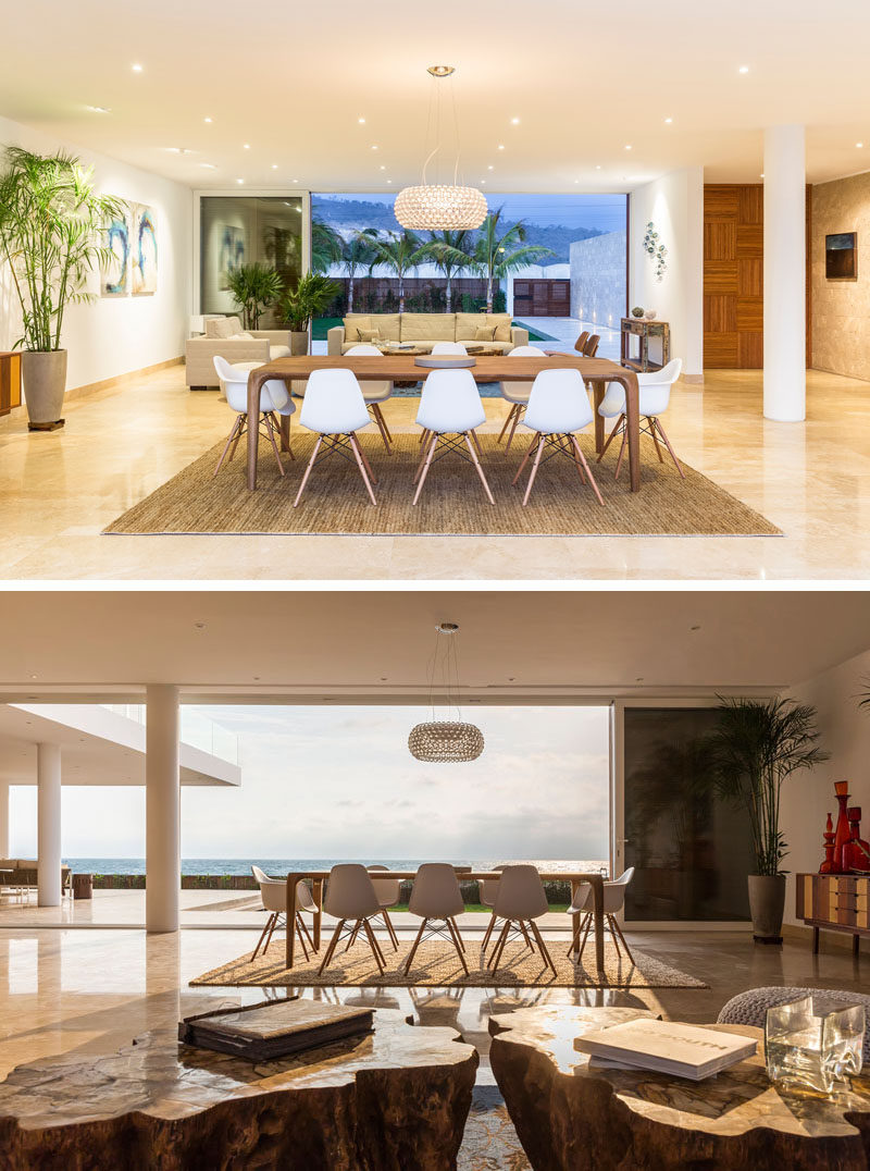 Heading inside this modern beach house, the dining and living room have a breathtaking view of the water. The combination of white, stone, and wood are used again inside the home to create a cohesive design. 