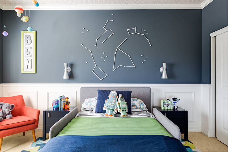 This space themed boy's bedroom has decorative constellation wall art on the blue-grey wall above the bed.