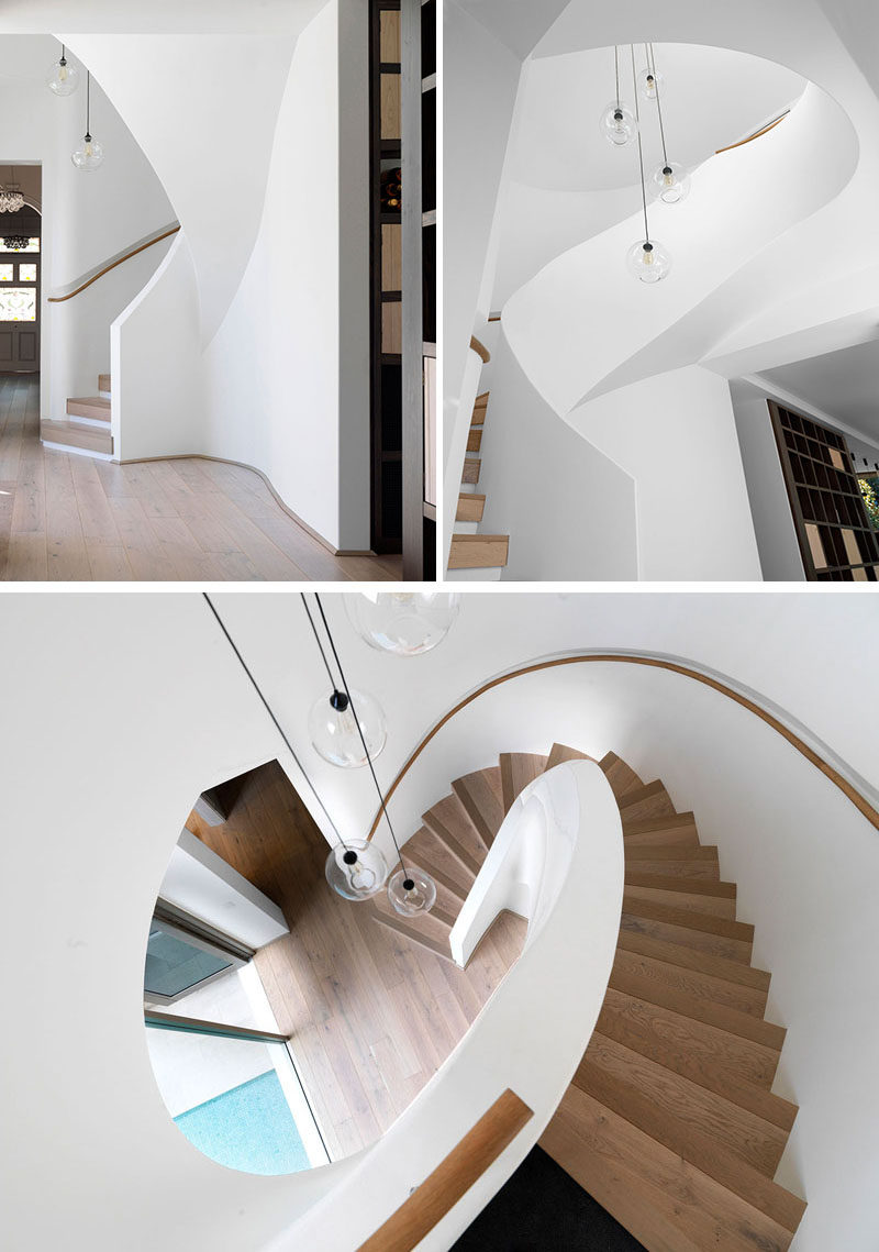 This white and wood spiral staircase links the old house to the new extension. White plaster has been finished with an enamel paint to protect it from children's fingerprints, and off to the side of the stairs is a wine storage wall.