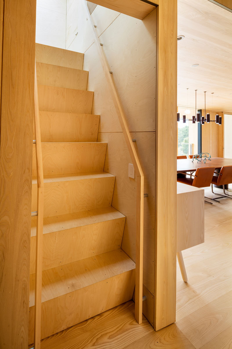 This wooden staircase (also known as a ships ladder staircase) leads to a cozy media room.