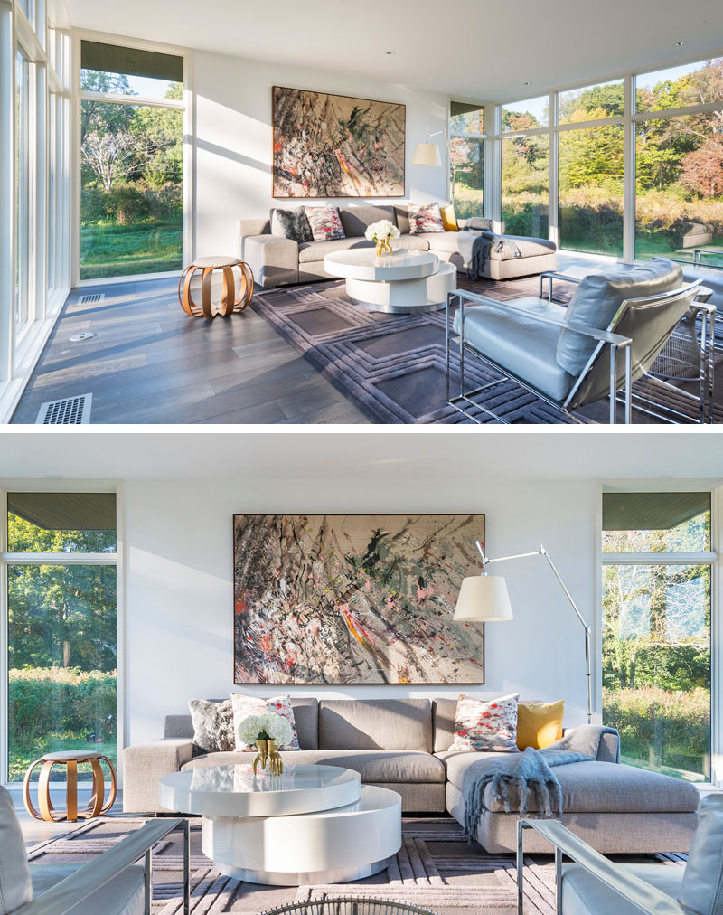 In this modern living room, views of outside can be enjoyed on the L-shaped upholstered sofa and grey leather arm chairs. A large graphic mounted art piece compliments the tones and hues use in the room. 