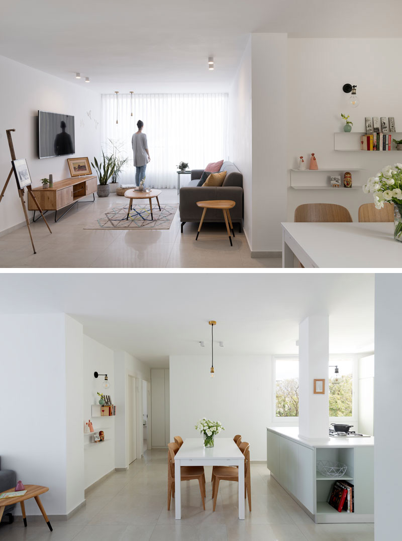 In this modern apartment, the dining area is defined by a white table with wood chairs that sits below a black and gold pendant light.