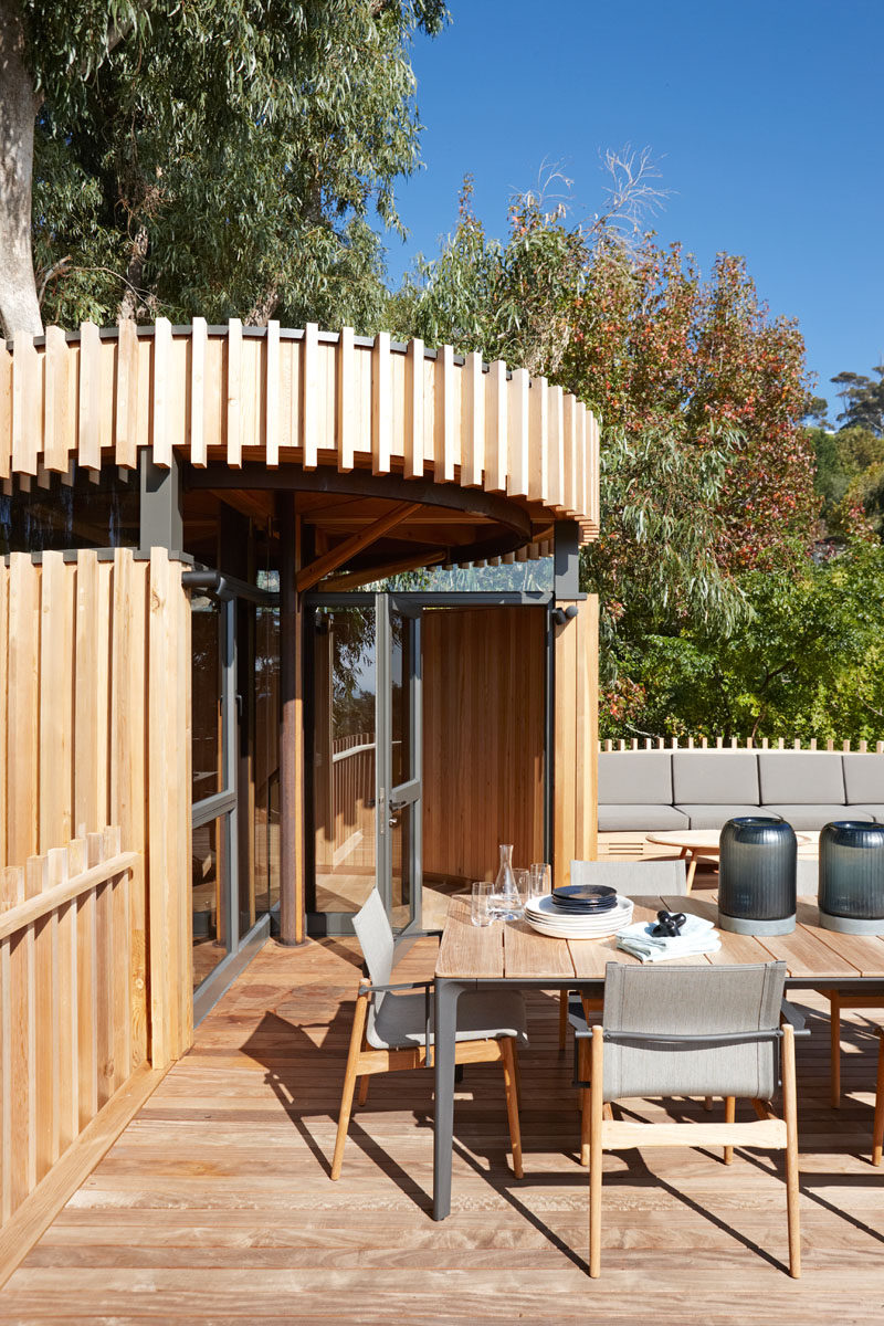 This modern grown-up tree house has a rooftop deck with a dining table and built-in seating. Being on the roof of the home makes it feel like you are dining in, and with the tops of the trees.