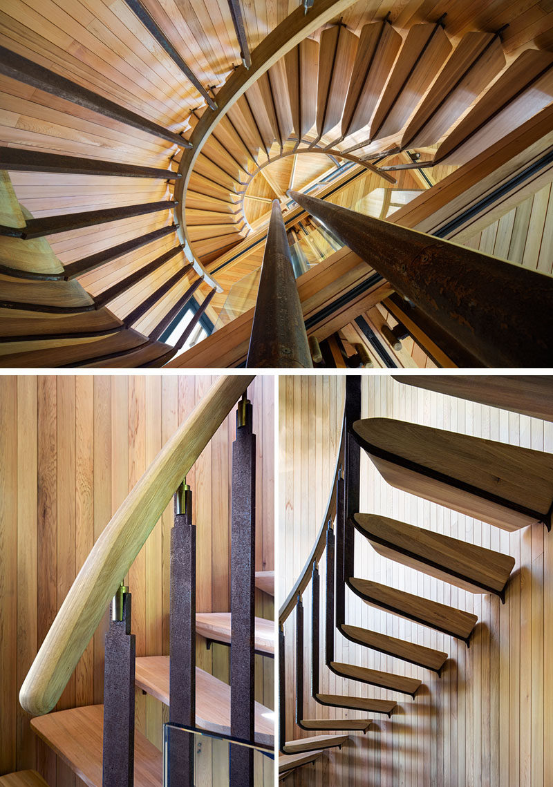 This spiral staircase with a wood handrail and steps wraps around steel support beams, and leads to the upper levels of the grown-up tree house.