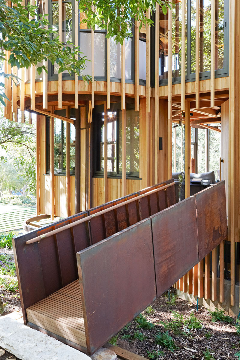 A raised timber and weathered steel ramp leads to the front entrance of the home, and into the first level of this modern house.