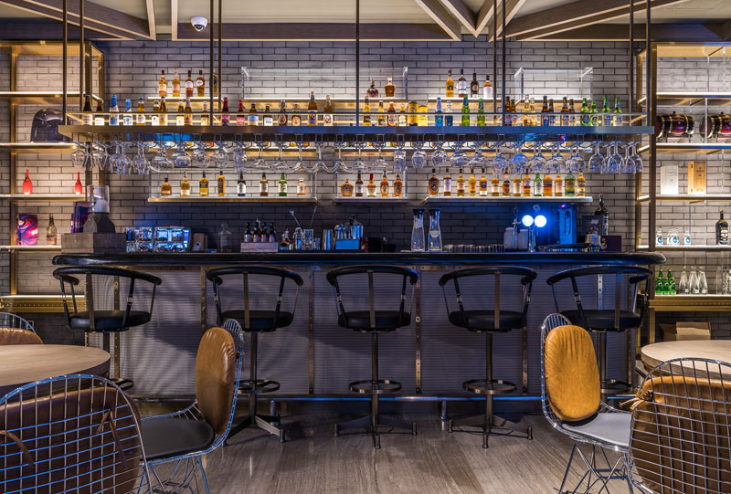 In this modern hotel bar, various metals are used throughout in decor and furniture to create a look that's more casual and laid back.