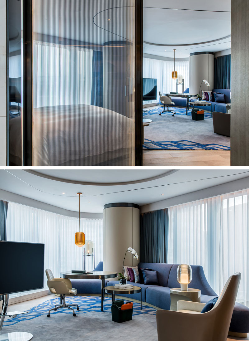 In this modern hotel room, floor-to-ceiling windows wrap around this suite creating the effect of a circular-like room that is big and open..