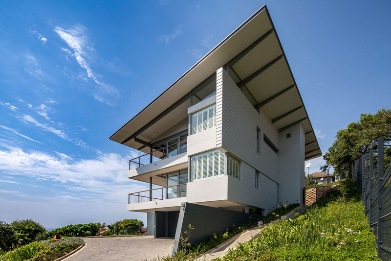 Around the back of this modern home, the structure is more private with little visibility of the interior of the home. Here the monopitch roof and cantilever form of the building is most visible. 