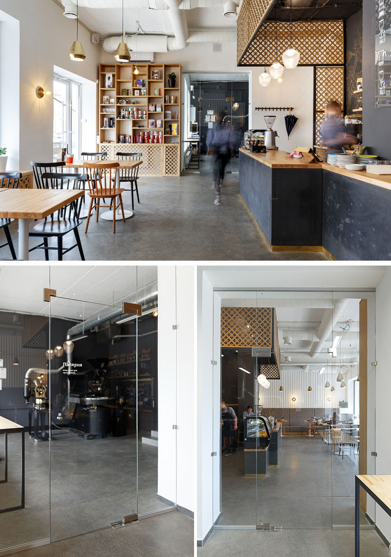 Opposite the main seating area in this modern coffee shop, is a large custom-built shelving unit that displays merchandise for sale. To the right of the shelving unit is a glass door that provides access to the roastery, allows visitors to watch the coffee beans being roasted, and helps to block the noise.