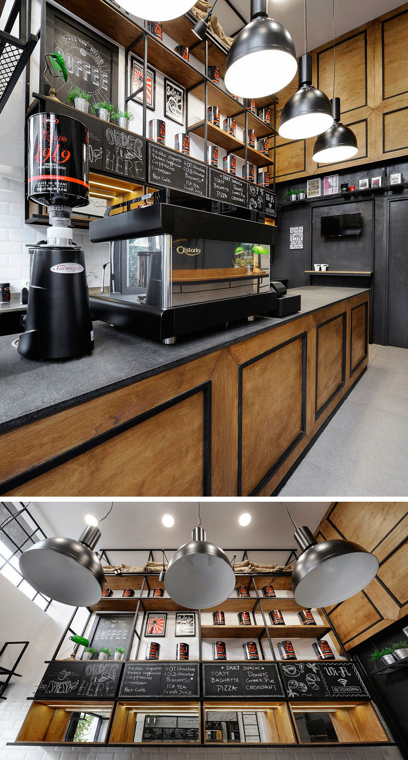 The service area of this modern coffee shop features a wood counter with dark countertop, while behind it, metal and wood shelves reach all the way to the ceiling.