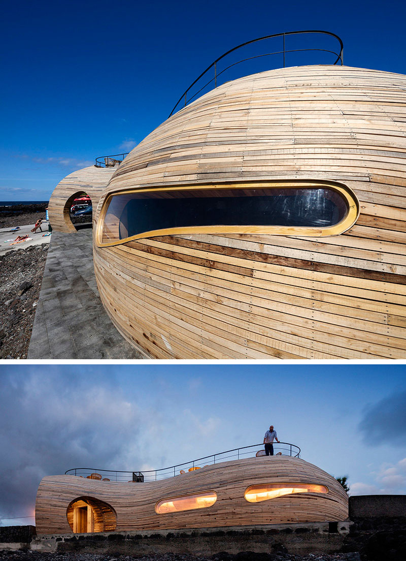 The sculptural exterior of this modern bar has long windows that organically flow with the wood building, and reveal a glowing interior at night. 