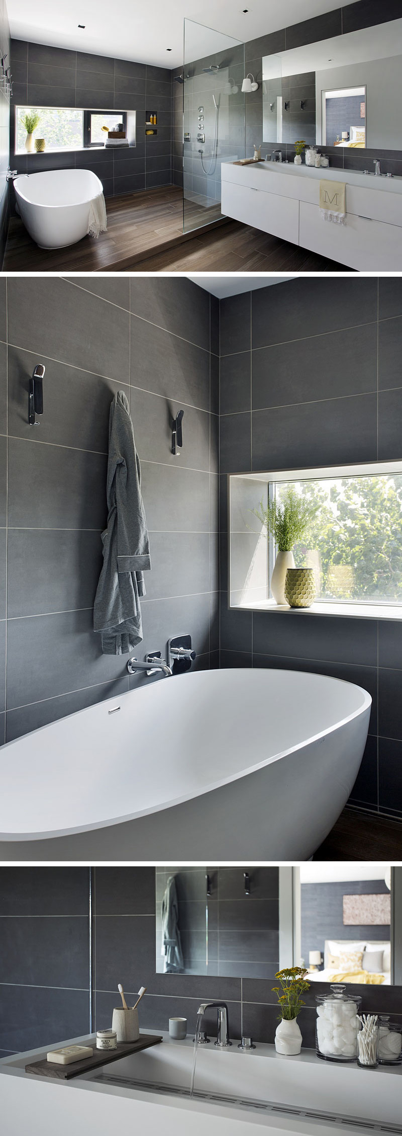 Large, dark grey rectangular tiles and wood flooring give this master bathroom a sophisticated look. The stand alone tub and shower area are slightly elevated above the rest of the room, with a glass partition separating the shower from the white vanity.