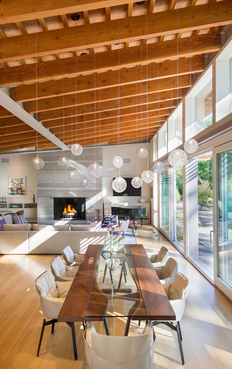 Delicate pendant lights have been used to create an artistic installation above the dining area in this open interior.