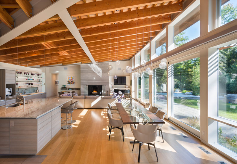 The main living area of this modern house has high ceilings with exposed beams and large 12 foot sliding glass doors that open up to a landscaped yard. 