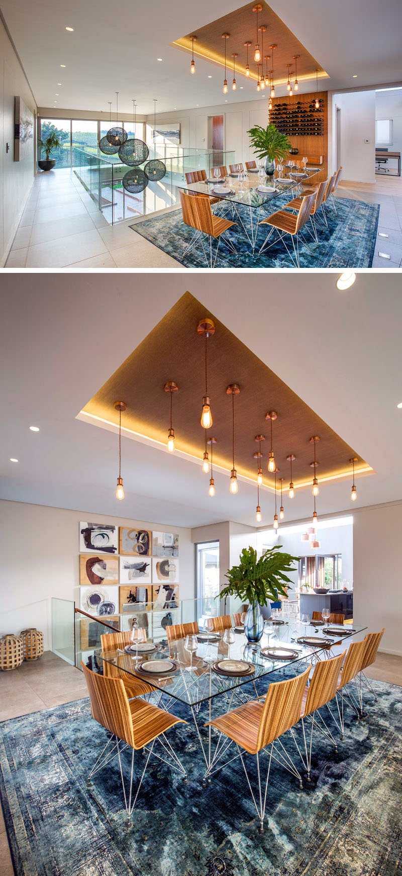 In this modern dining room, the glass topped dining table with wood chairs sits below multiple brass pendant lights hanging from a recessed ceiling. A large blue area rug below the table adds a pop of color to the room, and is not obstructed due to the glass table.