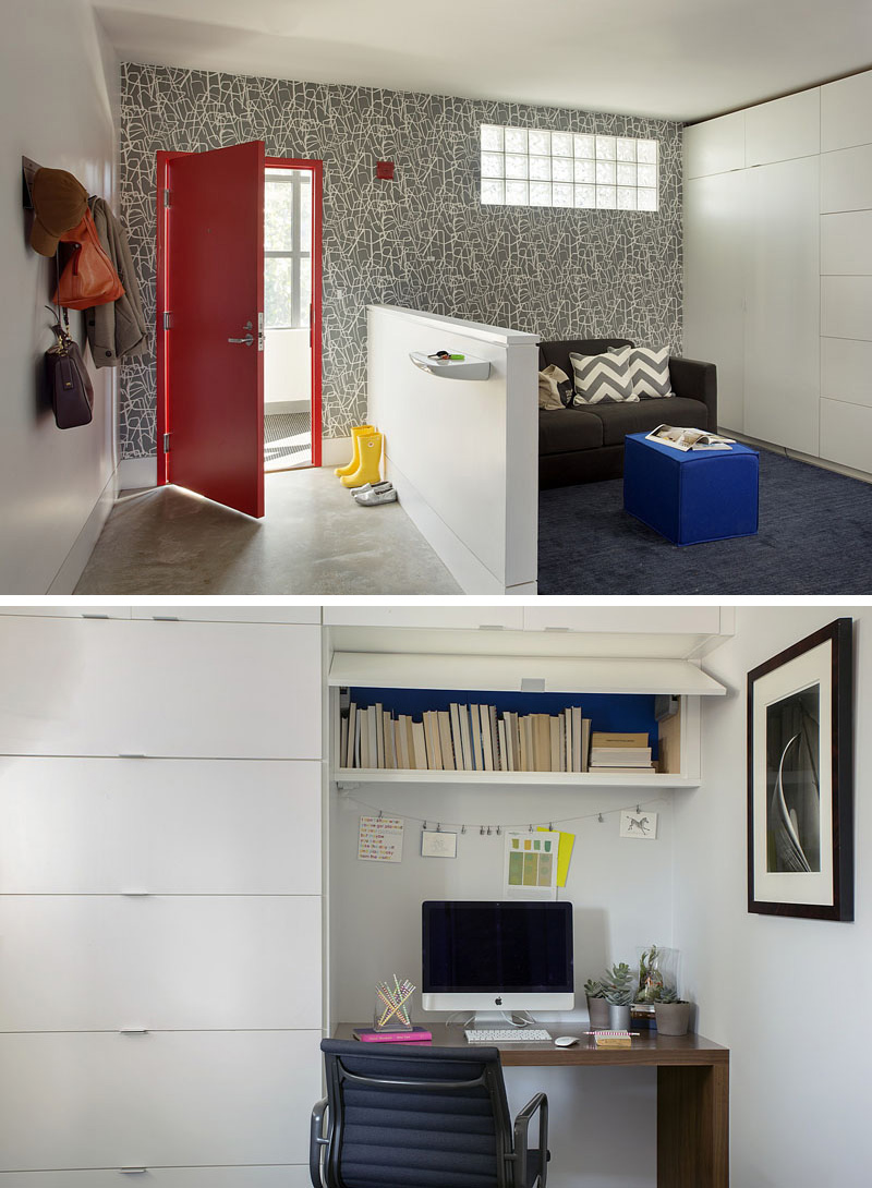 Just inside the front entrance of this modern loft, is a small sitting room with a wall full of floor-to-ceiling white cabinets. This area can be used as a home office (there's a small desk built into the cabinets) or as a sleeping area for guests. A red door and graphic wall paper give this space a bright and fun feeling.