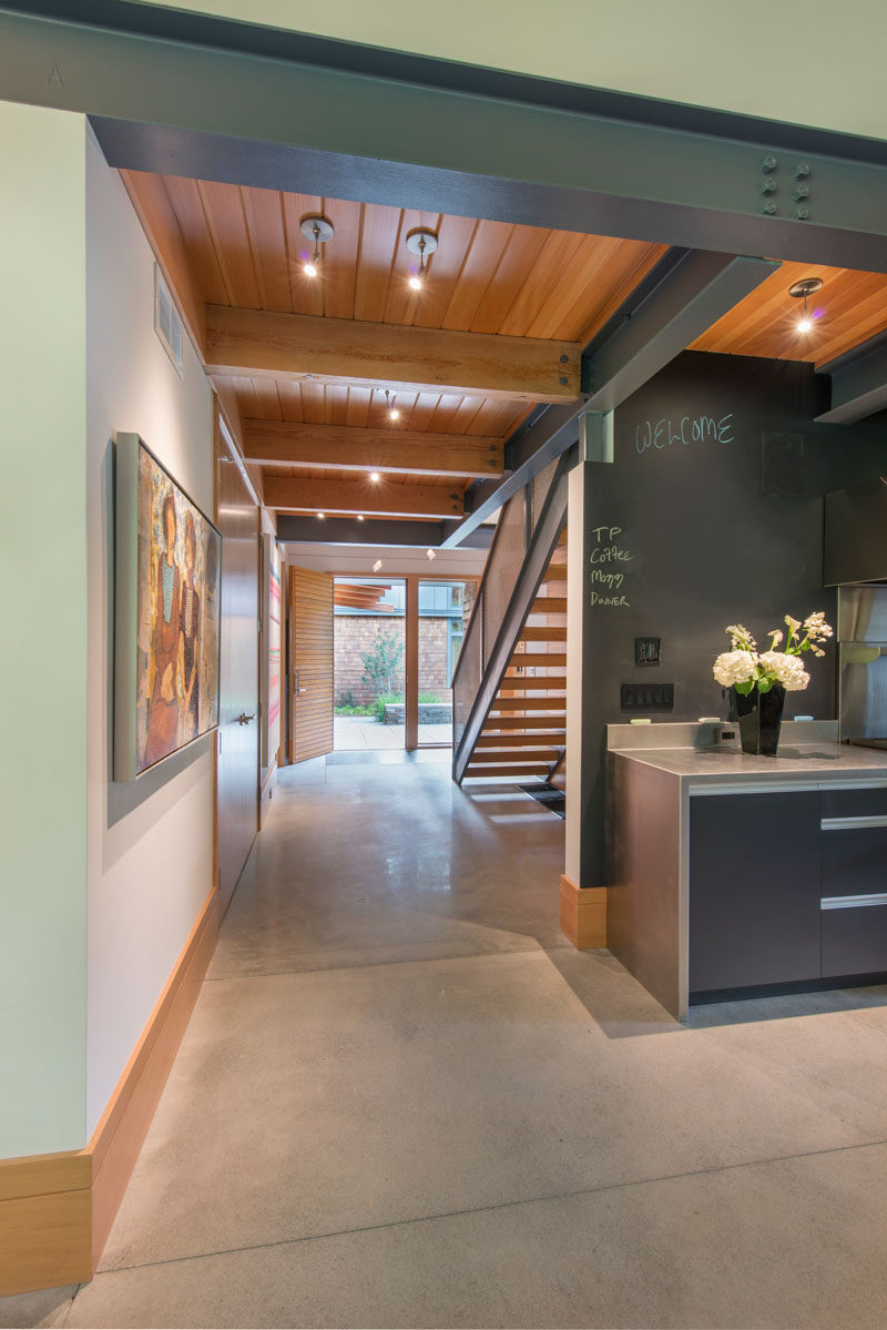 Light concrete floors, plaster walls, wood ceilings and steel beams make up the material palette of this modern house.