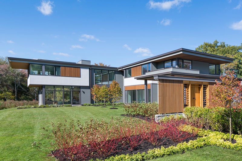 This modern house is on a blueberry farm and features wood accents, floor-to-ceiling windows, and a bright and airy interior. 