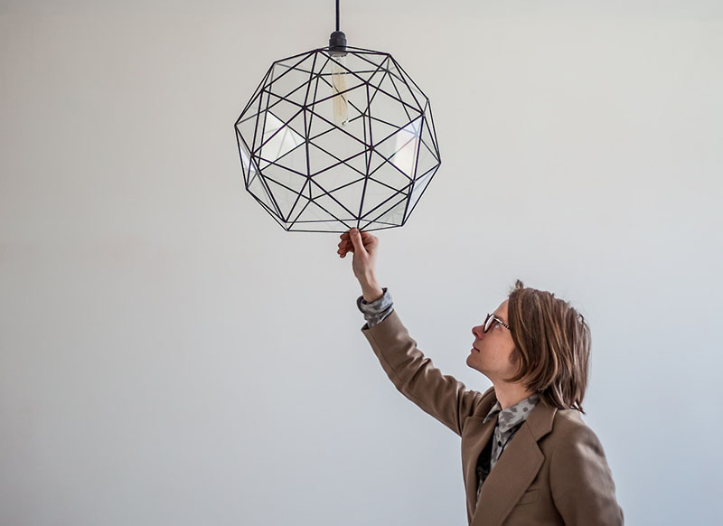 Glass pendant light with black detailing inspired by minimalism and geometry.