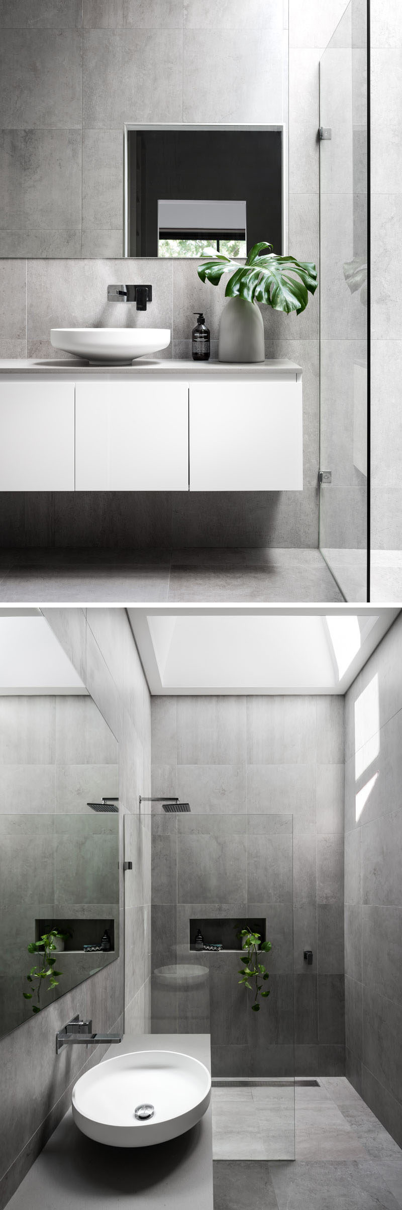 This modern master bathroom has a large grey tiles covering the walls and floors. A glass partition separates the shower from the white floating vanity, and a skylight adds plenty of natural light to the room.