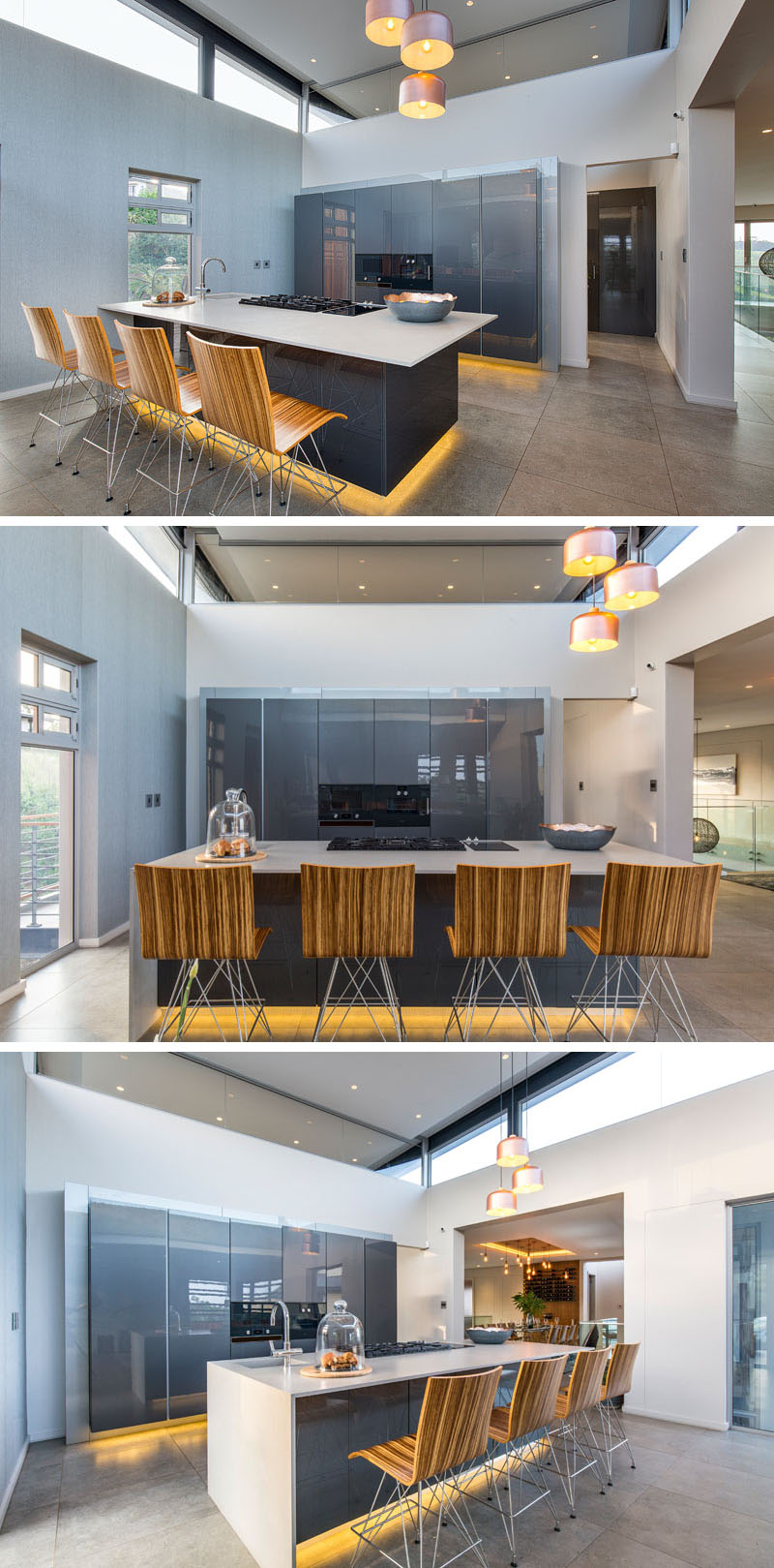 This modern kitchen has hidden lighting below the grey island and wall of cabinets make it appear as if they are floating. The glossy finish on the surfaces reflect the light making the room feel bright and open.