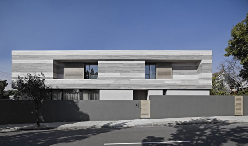 Designed by b.e.architecture, this modern grey house in Melbourne, Australia was made using a limited color palette. Natural and aged materials have been used to create the rectangular home.