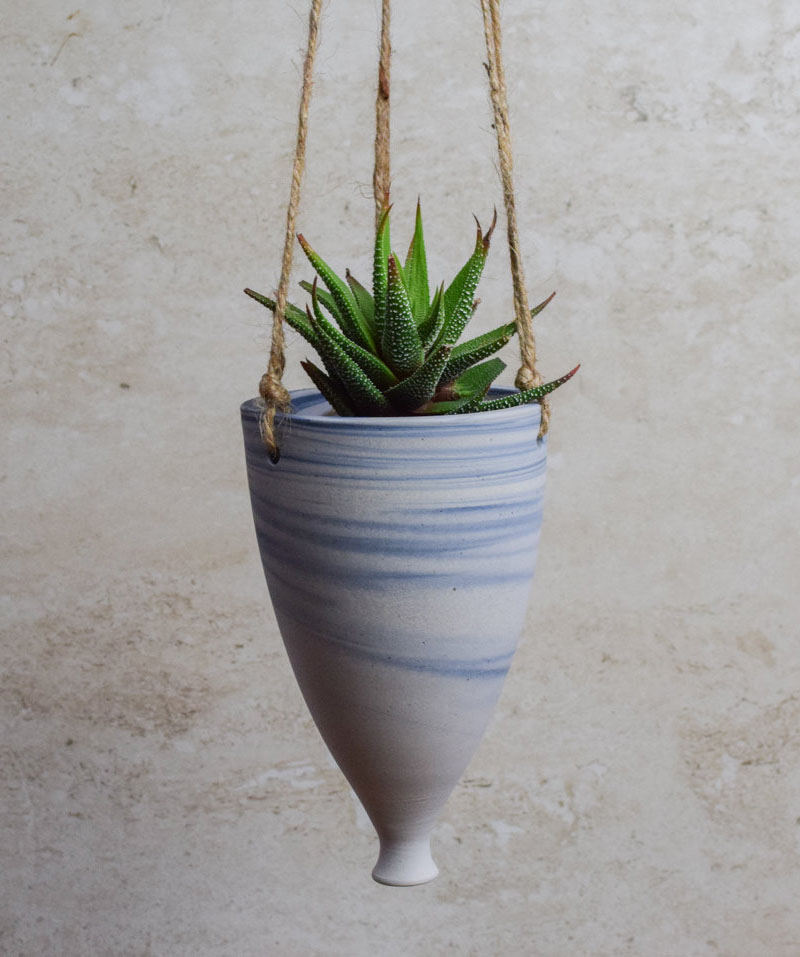 This blue and white ceramic hanging planter has a elongated shape and a marble effect. #HangingPlanter #ModernPlanter #HomeDecor #Garden #Plants