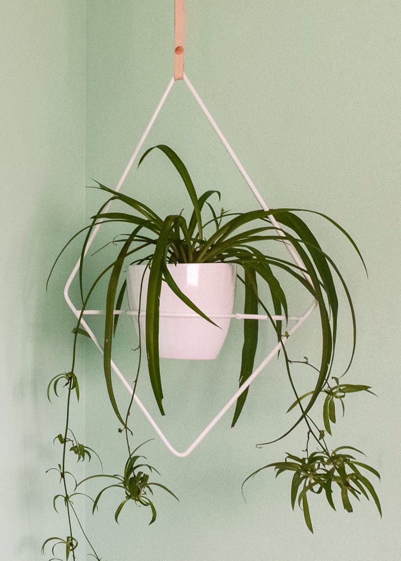 This white geometric planter is made front steel and hangs from a simple leather strap, while the shape of the planter frames the plant as an art piece.  #HangingPlanter #ModernPlanter #HomeDecor #Garden #Plants