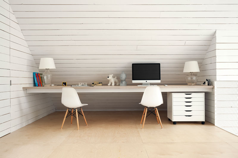 In a room almost entirely of white, this shared desk is creatively tucked in below the roof line creating usable space for this home office.