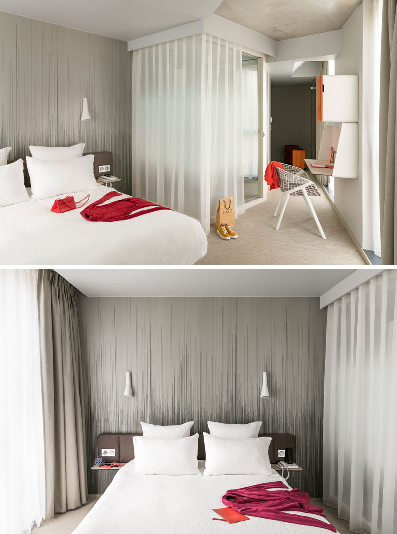 In this modern hotel room, a simple artistic wallpaper creates an accent wall behind the bed and adds to the neutral and sophisticated color palette of the room.