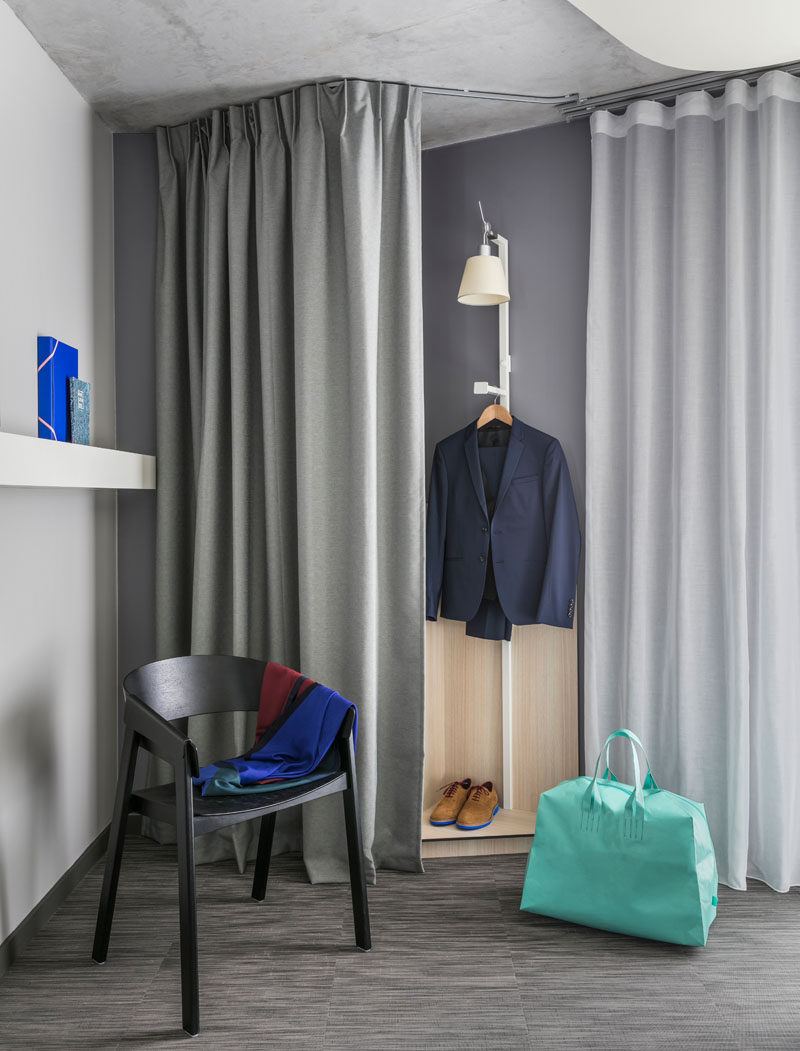 Curtains are used in this modern hotel room to hide a closet area.