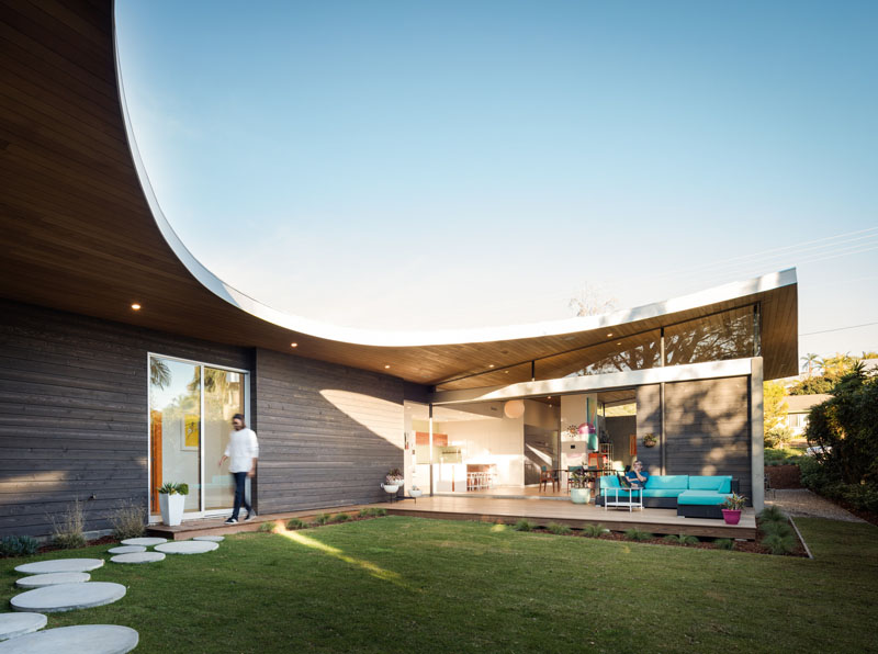 This modern and unique home has a curved roof, creating a U-shape floor plan.