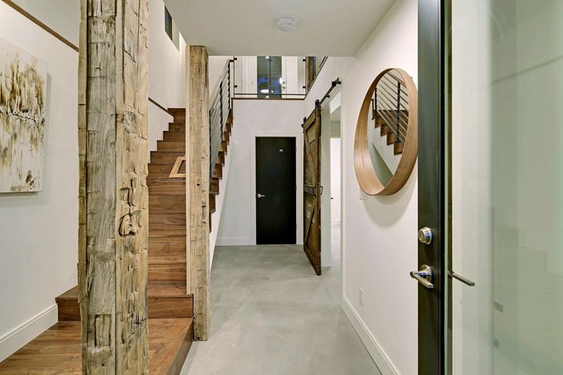 Inside this modern house, the interior posts have been made unique by wrapping them in a hundred year old hand-hewn wood from Montana.