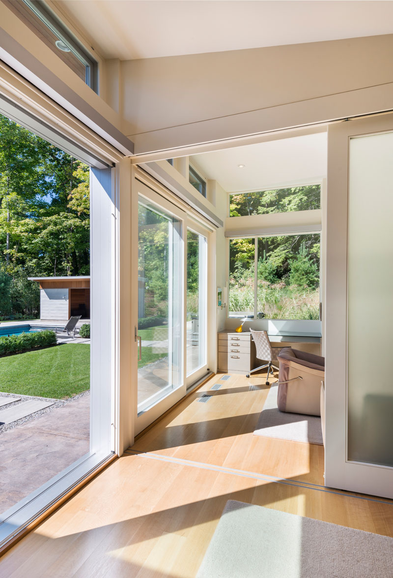 The bedroom and home office in this modern house both open up to the backyard and swimming pool.