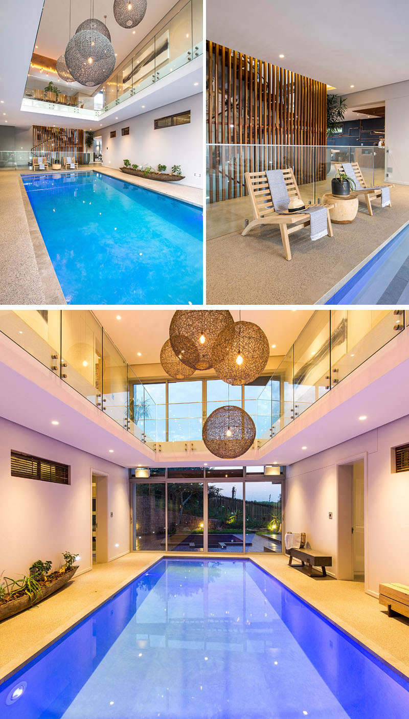 The layout of this modern house has been designed around the indoor swimming pool, with the hanging pendant lights making the most impact here. The blue pool reflects a warm glow due to the multiple lighting sources in the room.