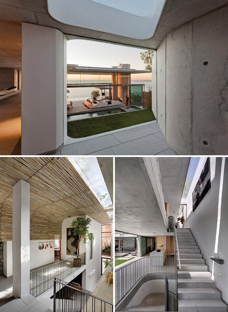  A modern concrete hallway brings you to a set of stairs that lead to the different levels of this house. A floor-to-ceiling window provides a glimpse of the courtyard below.