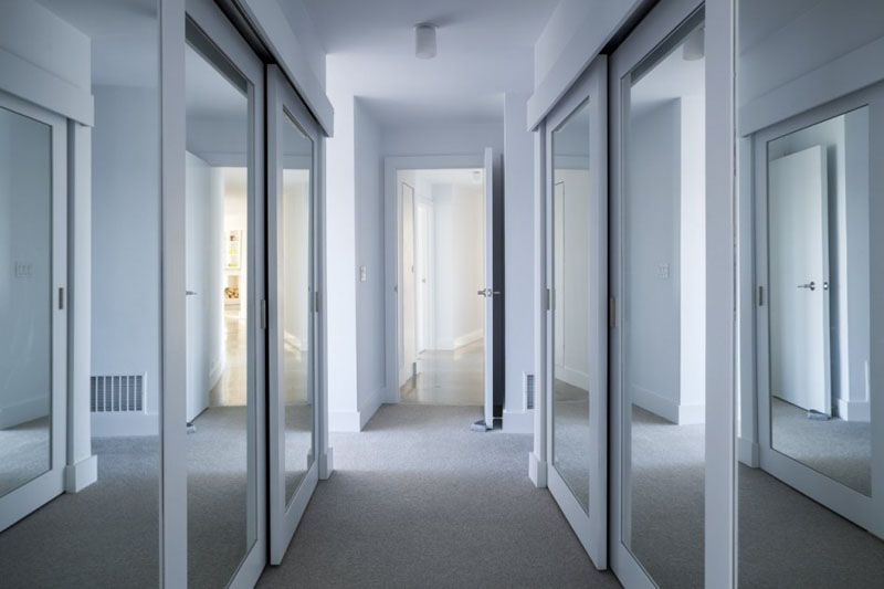 Leading to the sleeping quarters of this modern house is a hallway, and mirrored front closets guide you to the master bedroom.