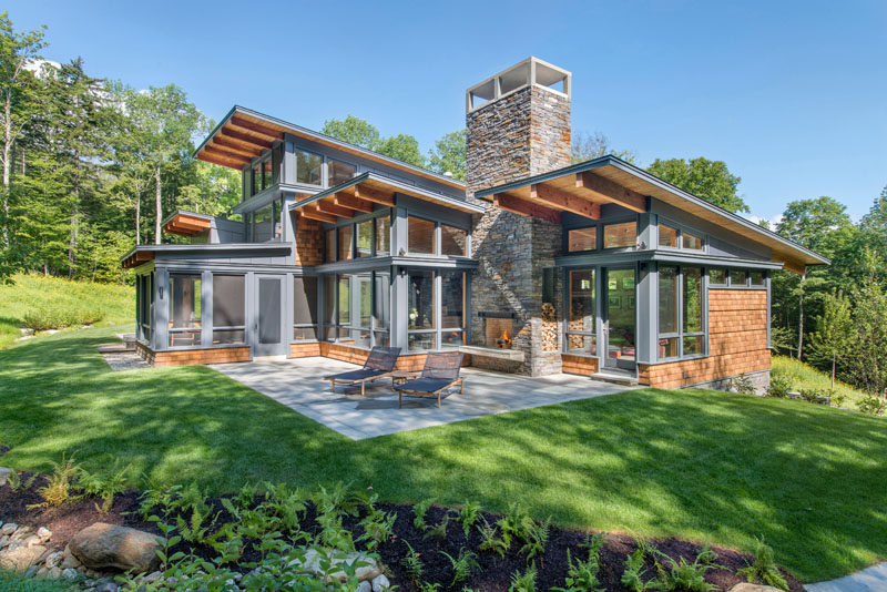 Flavin Architects have designed this modern shingle-covered house on a wooded property in Fayston, Vermont.