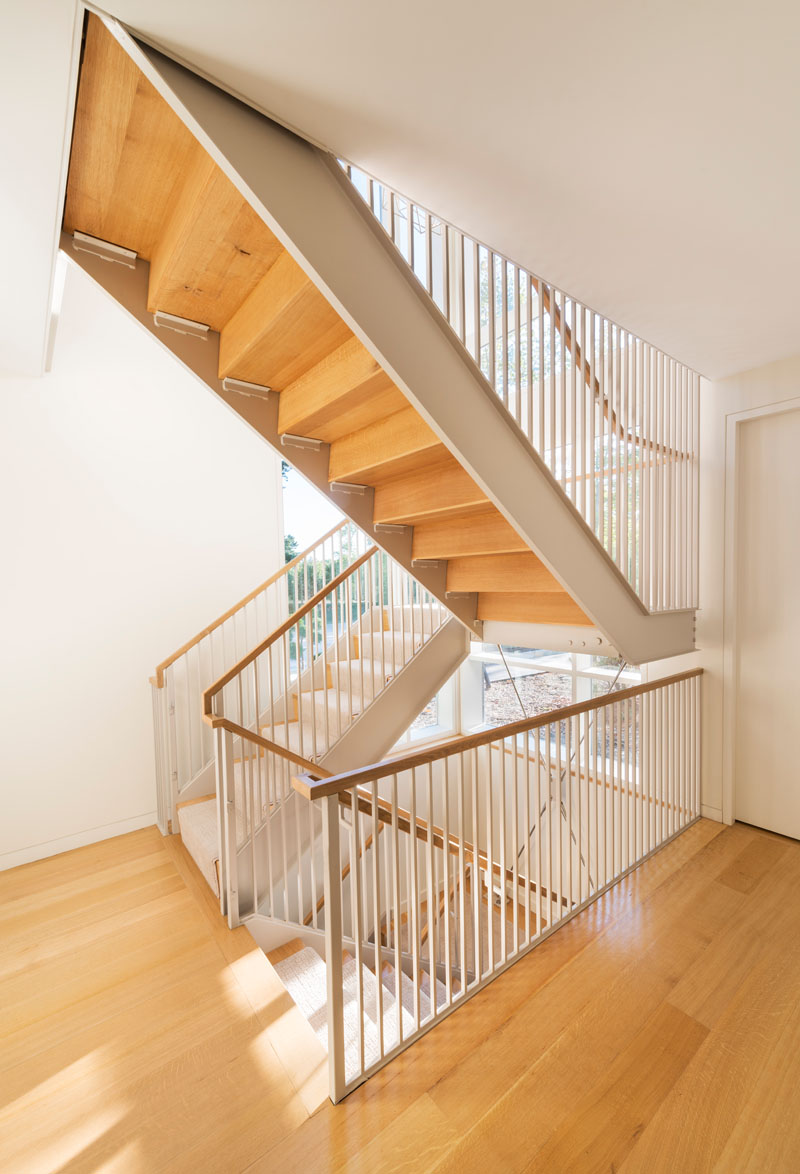 This modern staircase with wooden treads connect the various levels of the home. A light carpet that matches the walls has been used on the stairs.