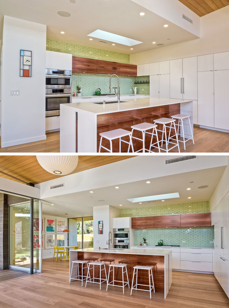  Light green hexagonal tiles are used as a backsplash in this modern kitchen. A large white and wood island compliments the white and wood cabinetry used in the room.