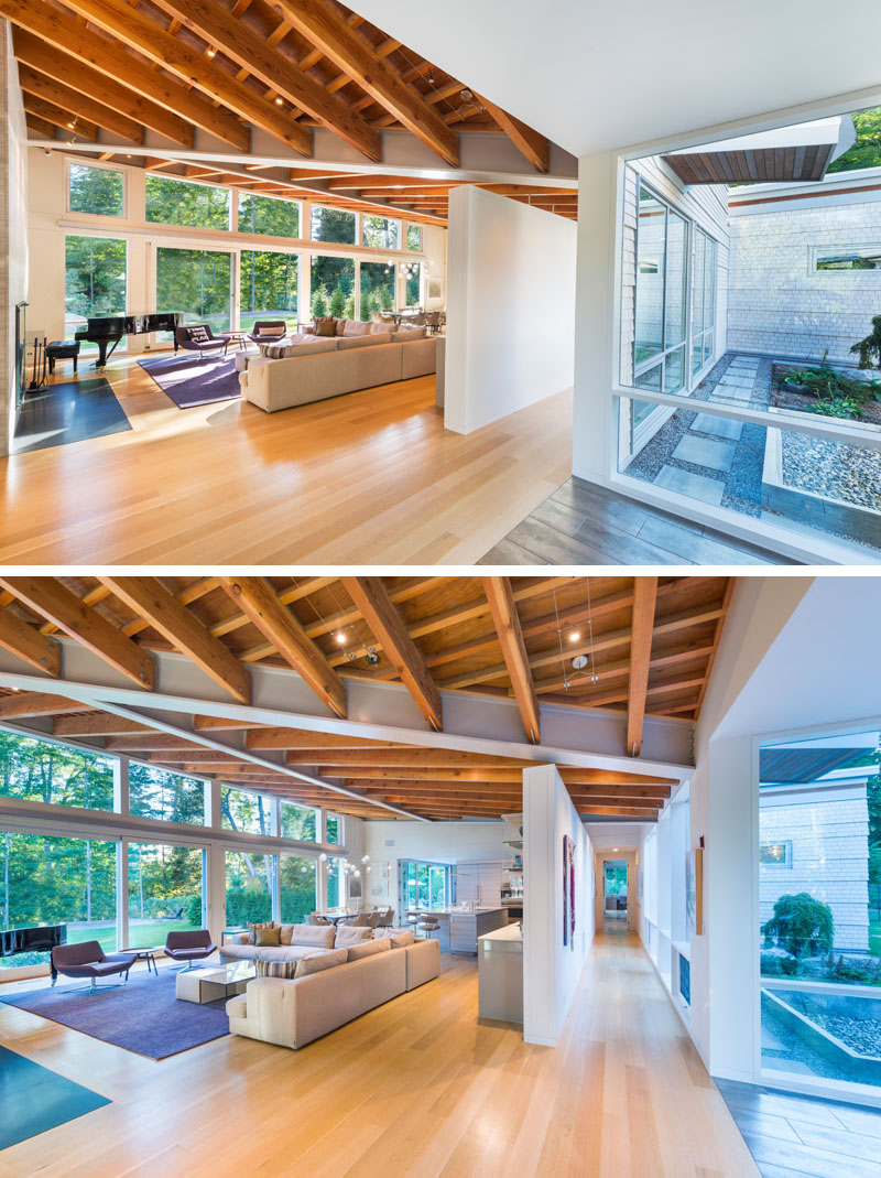 The main living area of this modern house has high ceilings with exposed beams and large 12 foot sliding glass doors that open up to a landscaped yard. 